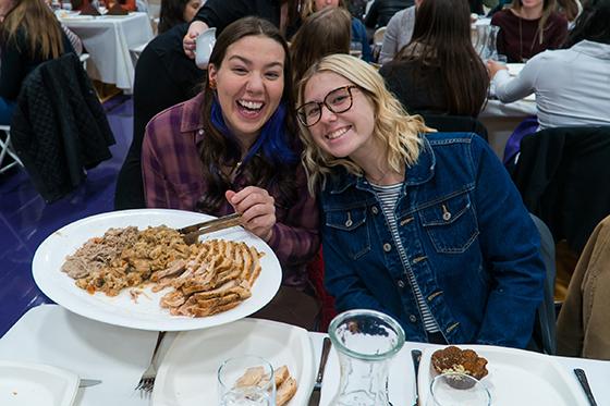 Photo of Chatham University students at 收获的晚餐 holding a plate of turkey and stuffing. 